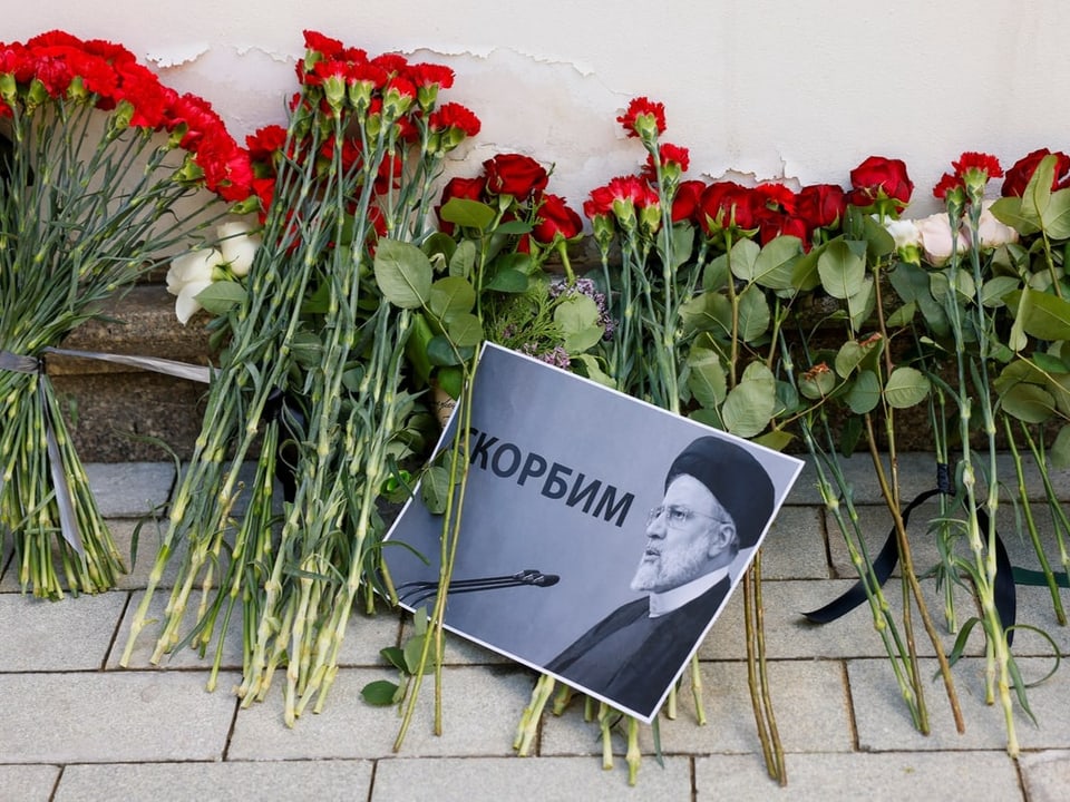Blumen und ein Foto eines Mannes als Gedenkstätte.