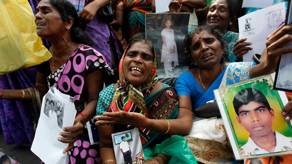 Tamilische Frauen mit Bildern von Verwandten demonstrieren.