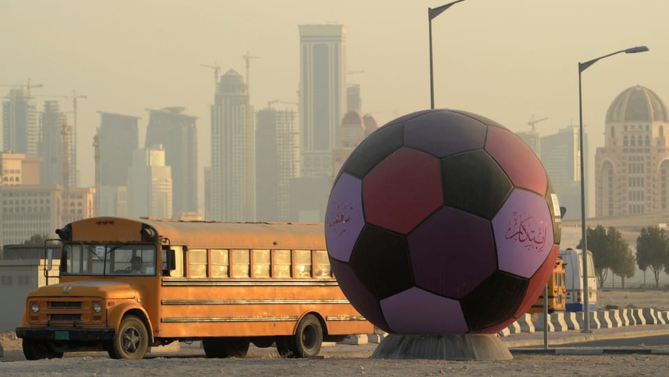 Überdimensionierter Fussball vor der Skyline von Doha