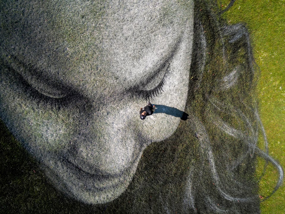 Ein auf Rasen gemaltes Mädchen in Nahaufnahme. Das Foto zeigt einen Ausschnitts des Werks im Irchelpark.