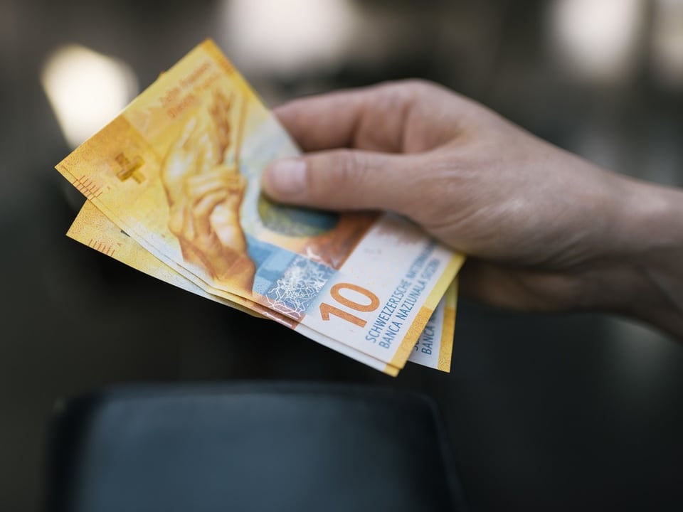 Eine Zehnernote in der Hand eines Mannes