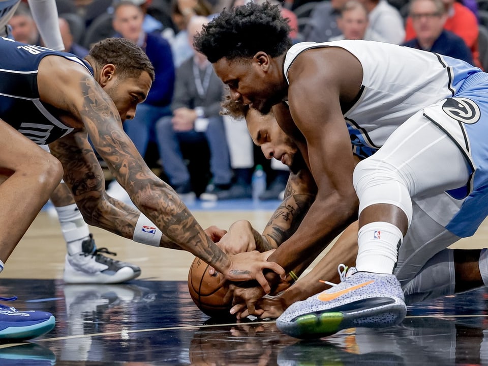 Basketballspieler kämpfen um den Ball auf dem Spielfeld.