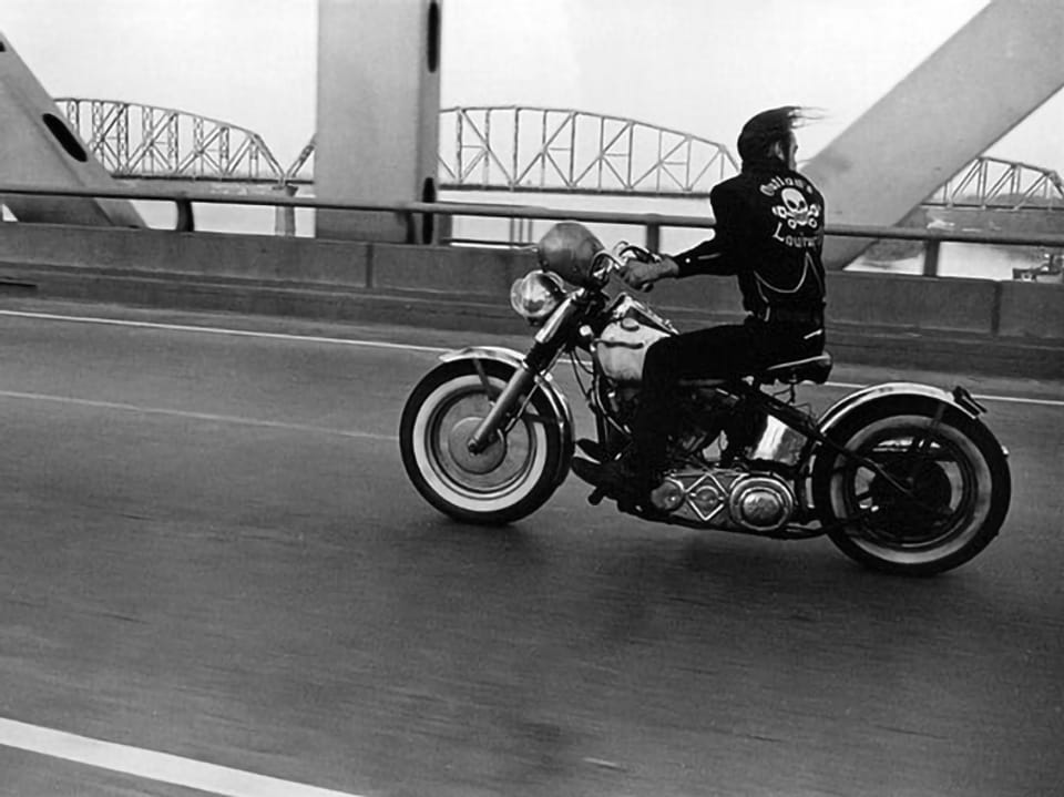 Ein Motorrad fährt auf einer Brücke