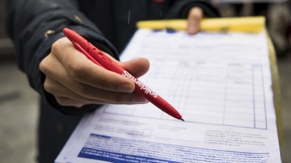 Hand, die einen roten Stift und ein Formular hält.