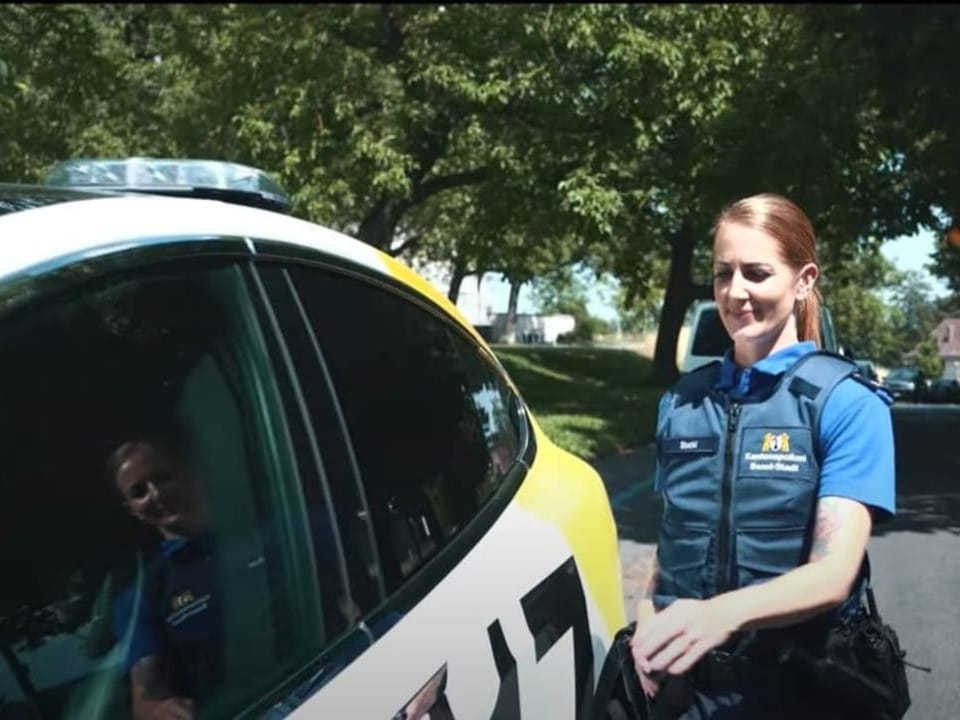 Eine Polizistin steigt in ihren Dienstwagen. 