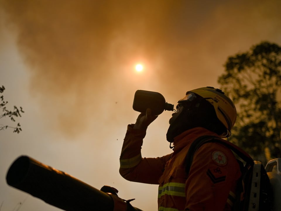 Feuerwerhrmann trinkt aus Flasche.