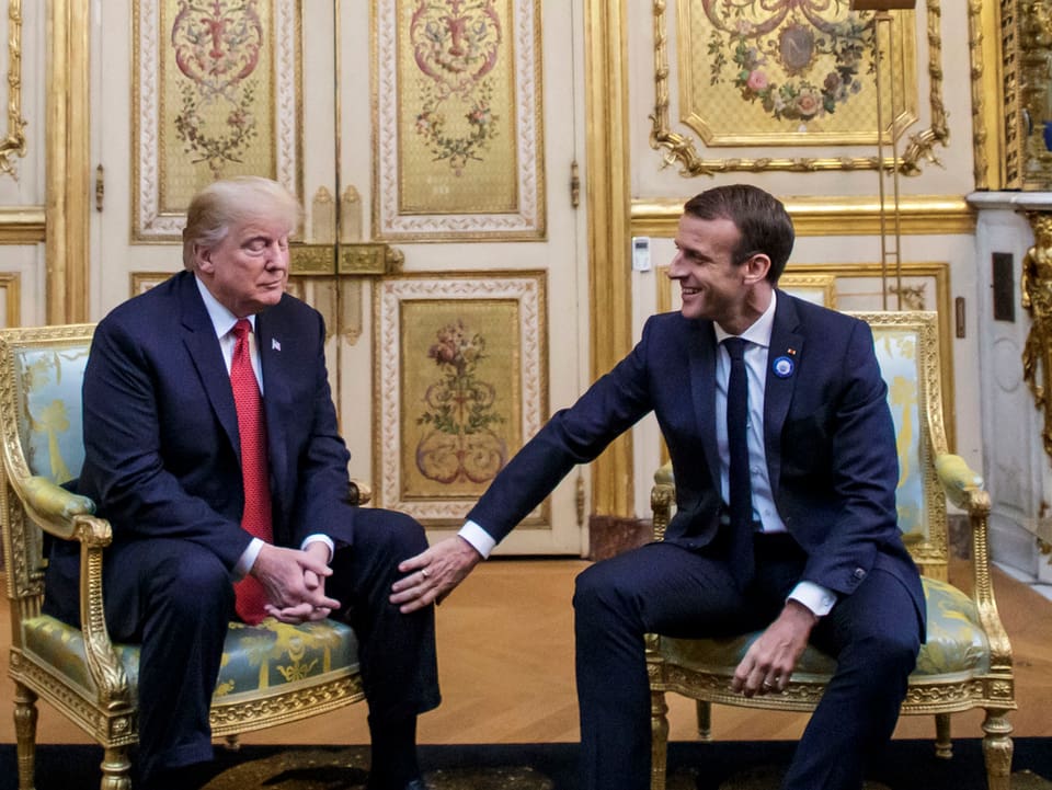 Trump und Macron sitzend.