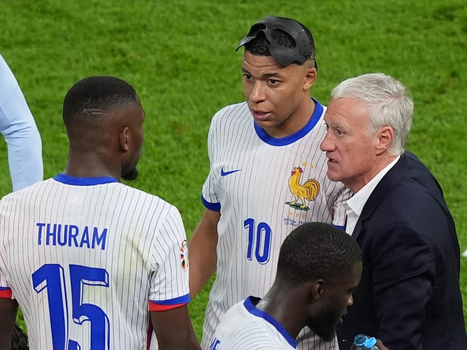 Französische Fussballspieler und Trainer im Gespräch.