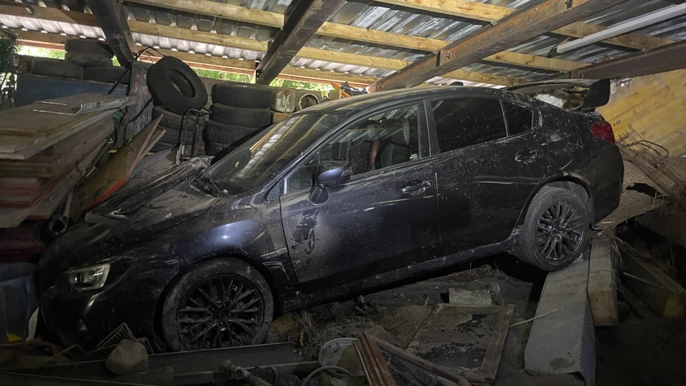 Ein zerstörtes Auto in einem von einer Schlammlawine getroffenes Gebäude.