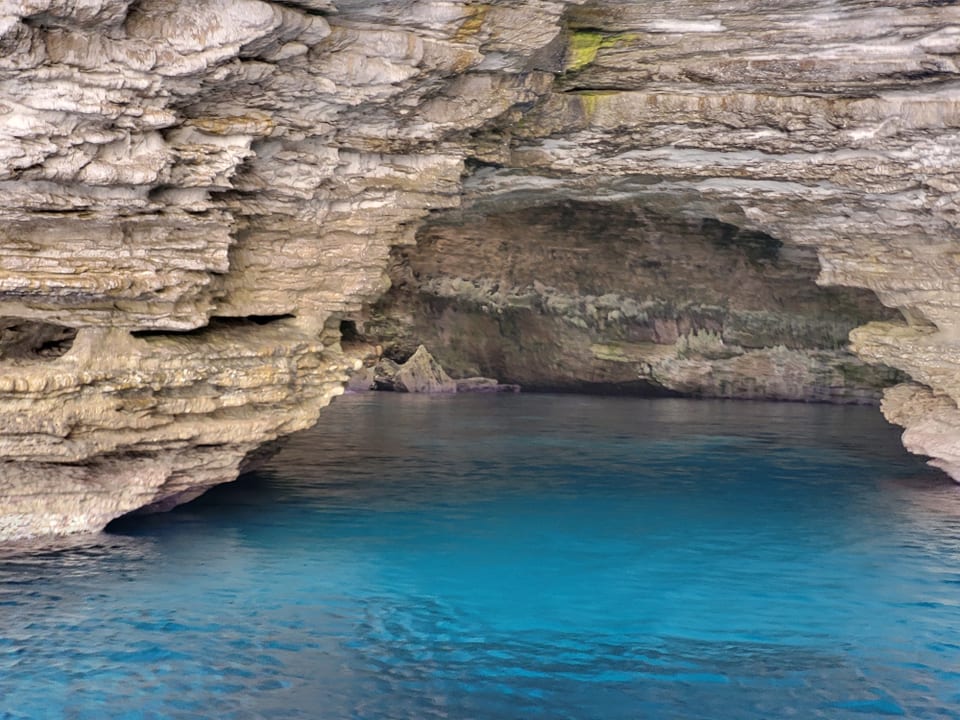 Natürliche Felsenhöhle mit blauem Wasser.