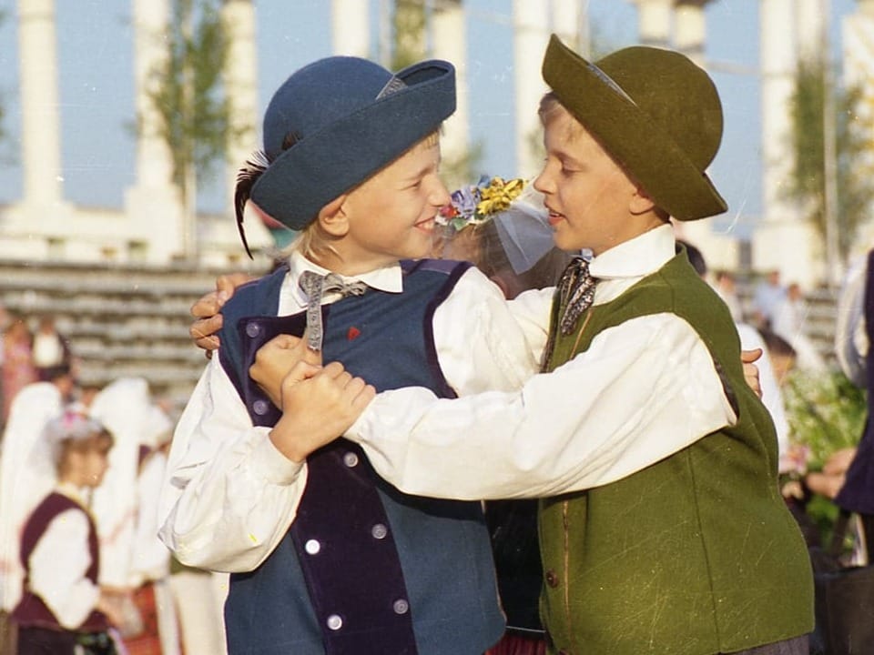 Zwei Jungen in traditioneller Kleidung tanzen.