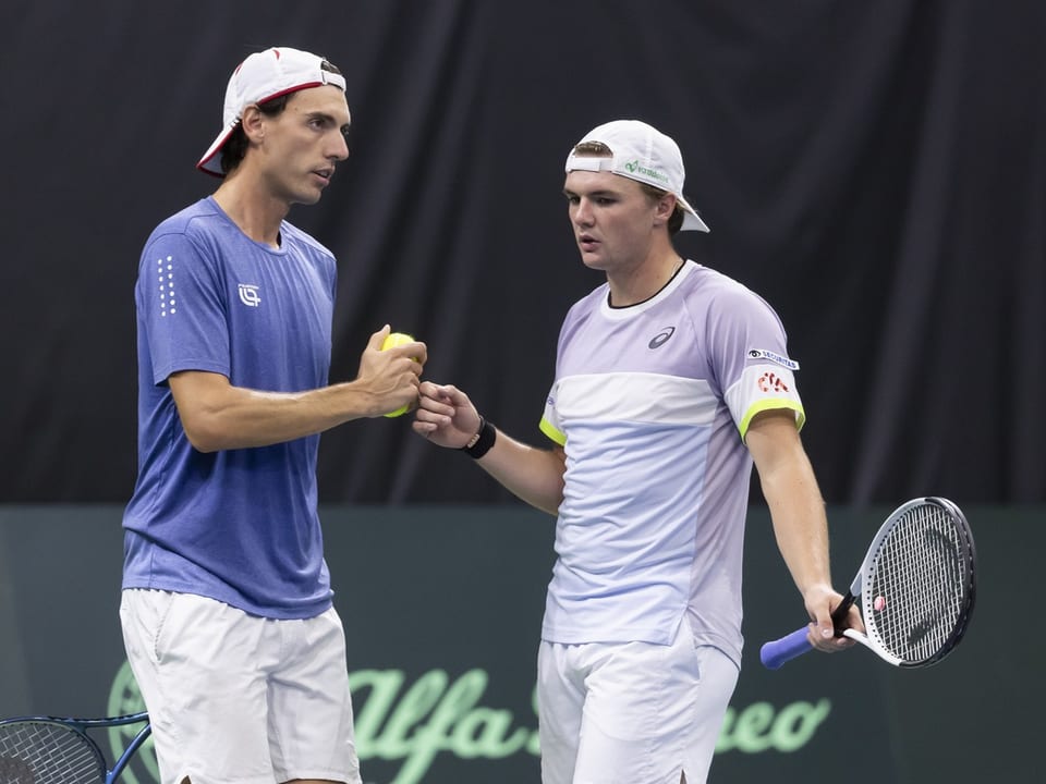 Two tennis players in conversation in the game.