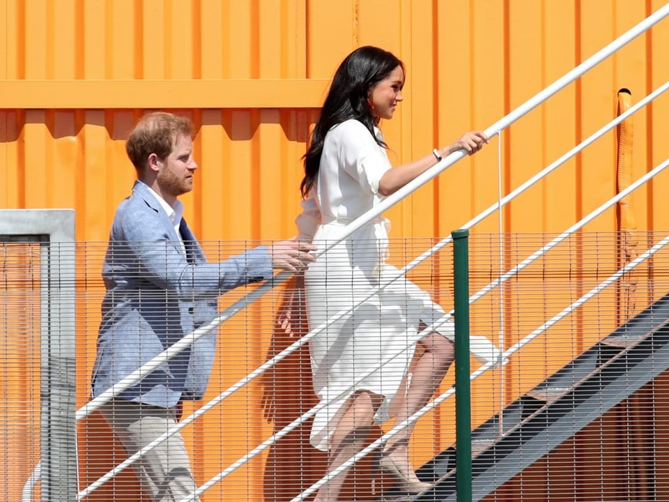 Harry und Meghan gehen eine Treppe hinauf.