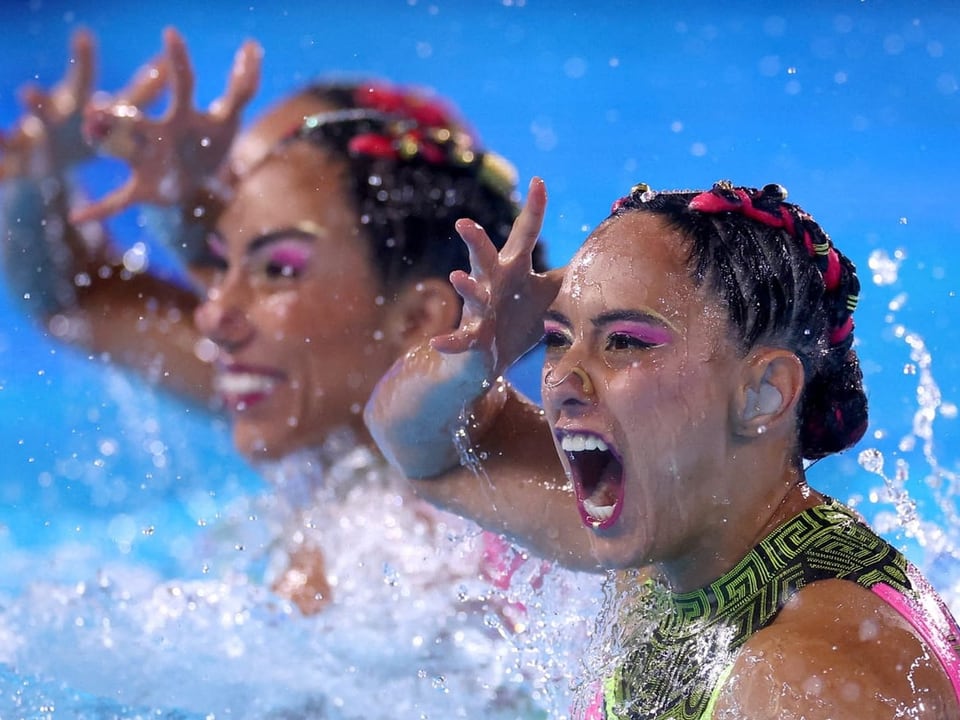 Synchronisierte Schwimmerinnen während einer Performance im Wasser.