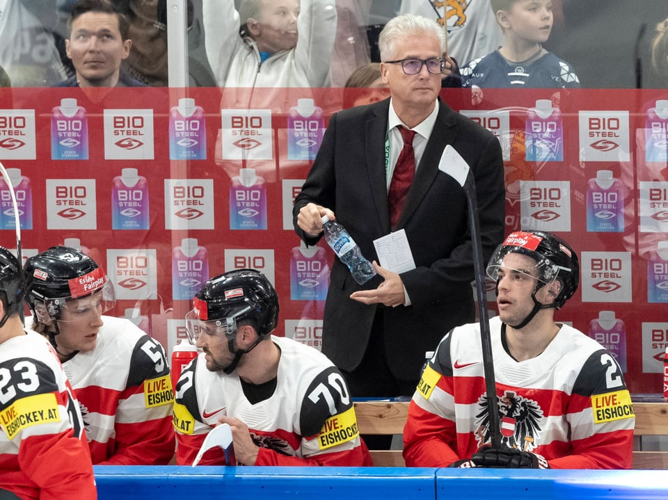 Hockeyspieler und Trainer auf der Bank während eines Spiels.