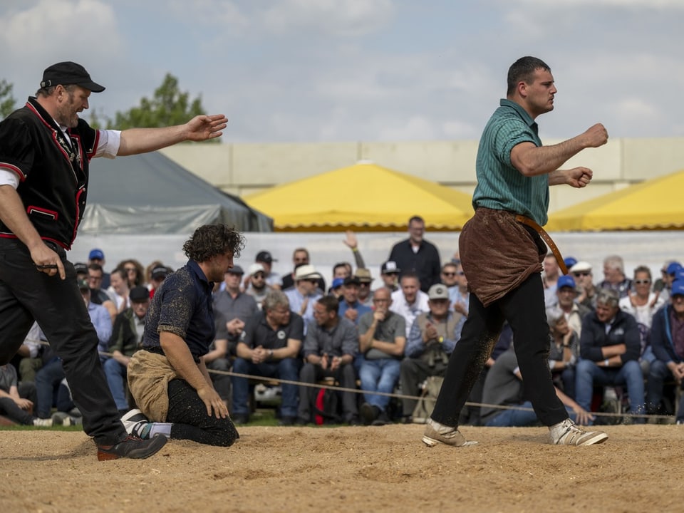Männer bei einem traditionellen Schwingen-Wettkampf vor Zuschauern