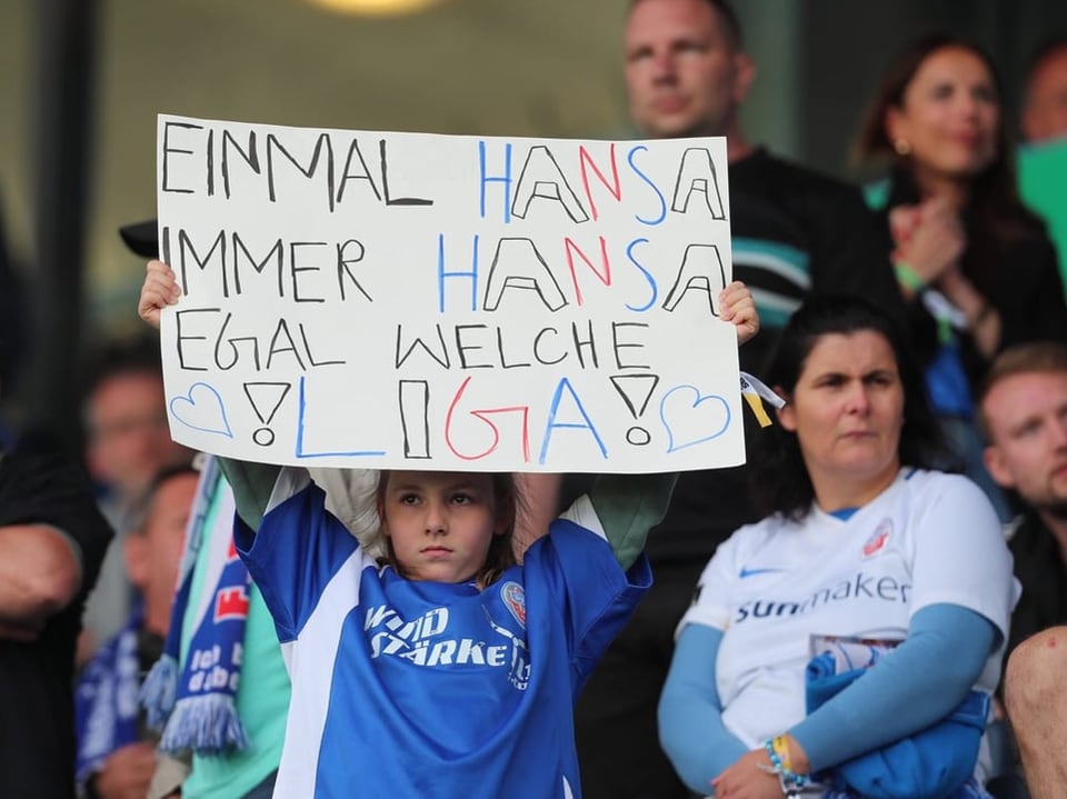 Fan hält Plakat hoch mit der Aufschrift: "Einmal Hansa, immer Hansa, egal welche Liga!"