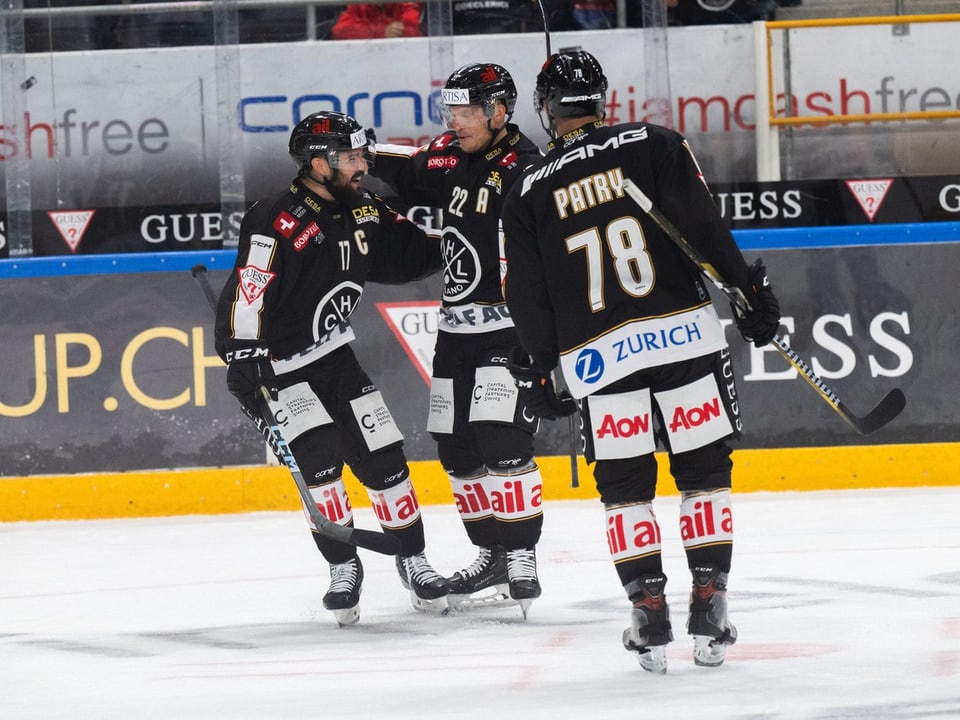 Three Eihockey players in black Trikots at Feiern auf dem Eis.