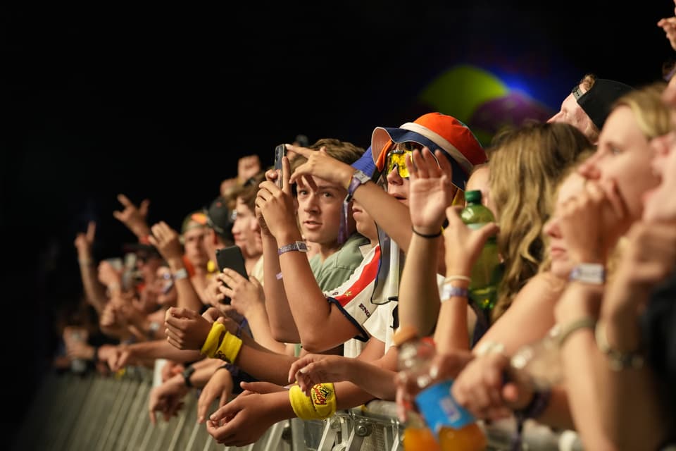 Menschenmenge bei einem Konzert, Fans in der ersten Reihe.