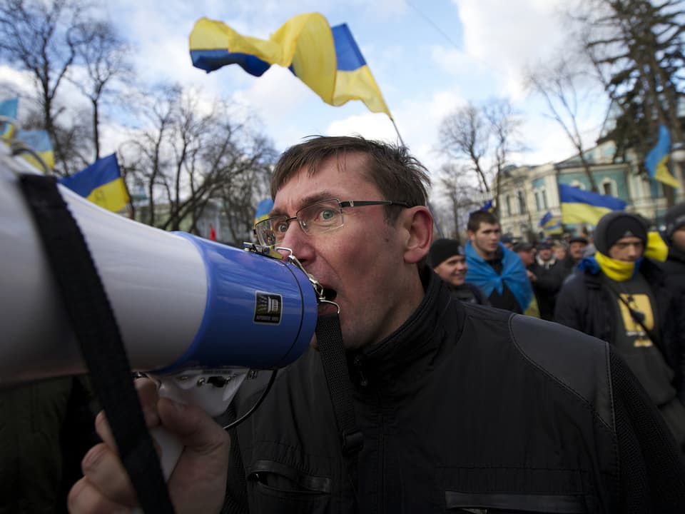 Mann mit Megaphone im Protestzug.