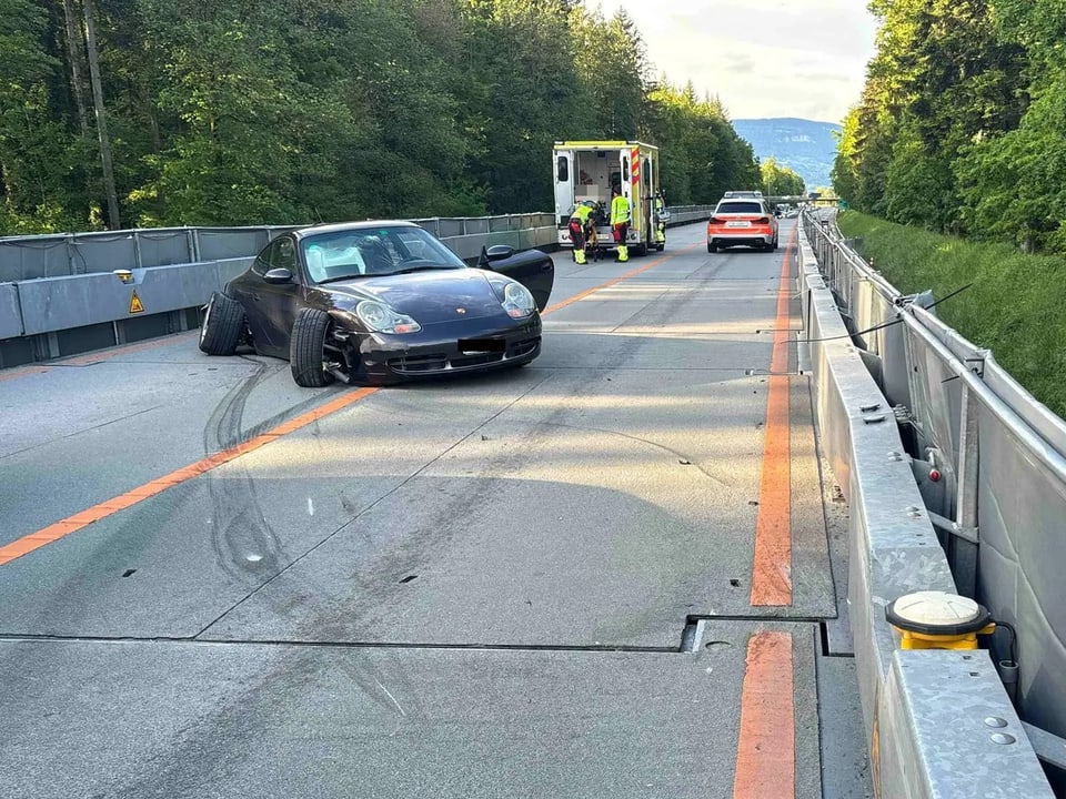 Autounfall auf der Autobahn mit Einsatzfahrzeug im Hintergrund.