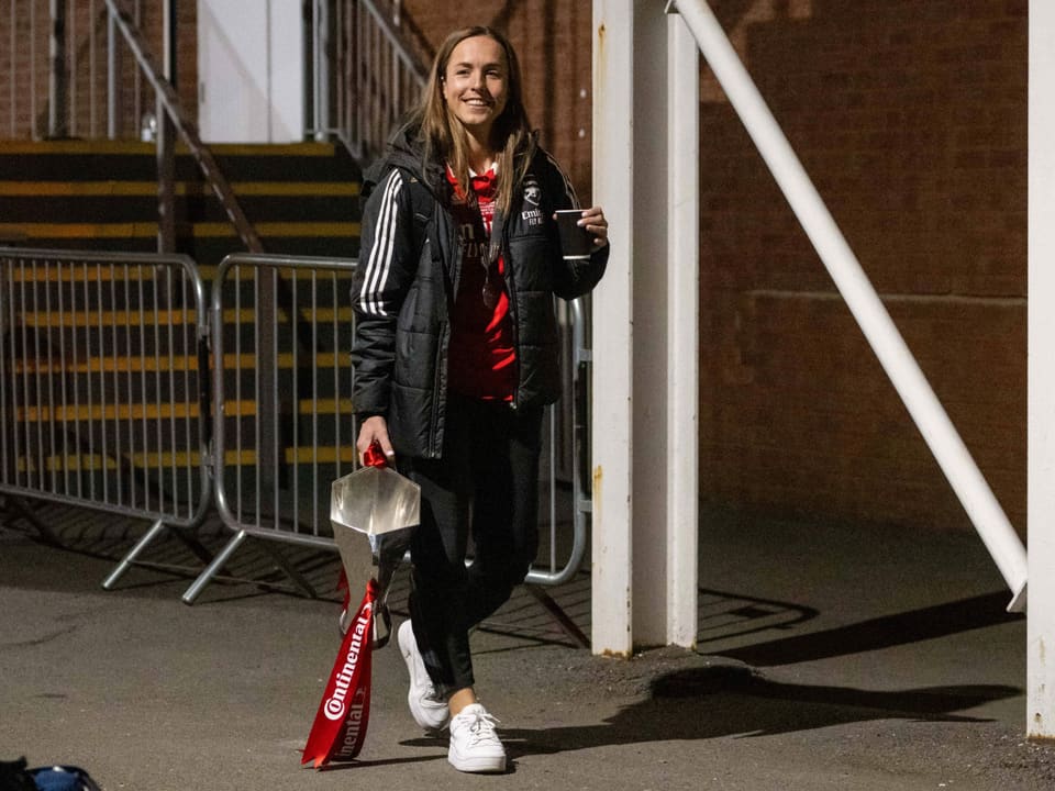 Lia Wälti im Trainingsoutfit mit dem Pokal und einem Getränk in der Hand