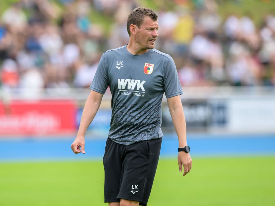 Trainingsanzug-tragender Mann auf Fussballfeld.