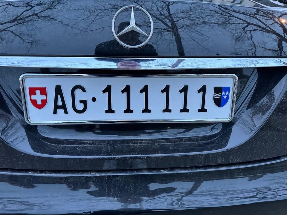 Schweizer Autokennzeichen AG 111111 an schwarzem Mercedes.