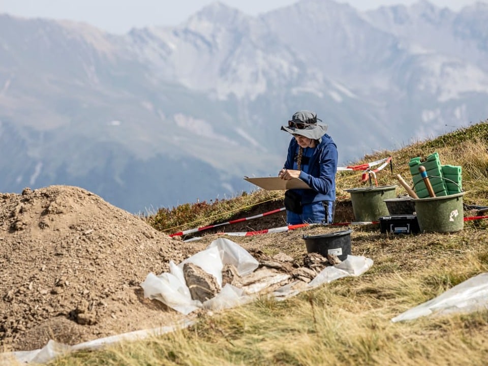 Archäologe dokumentiert Funde bei Ausgrabung in den Bergen.