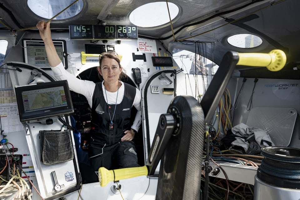 Frau im Segelbootcockpit mit Navigationsgeräten.