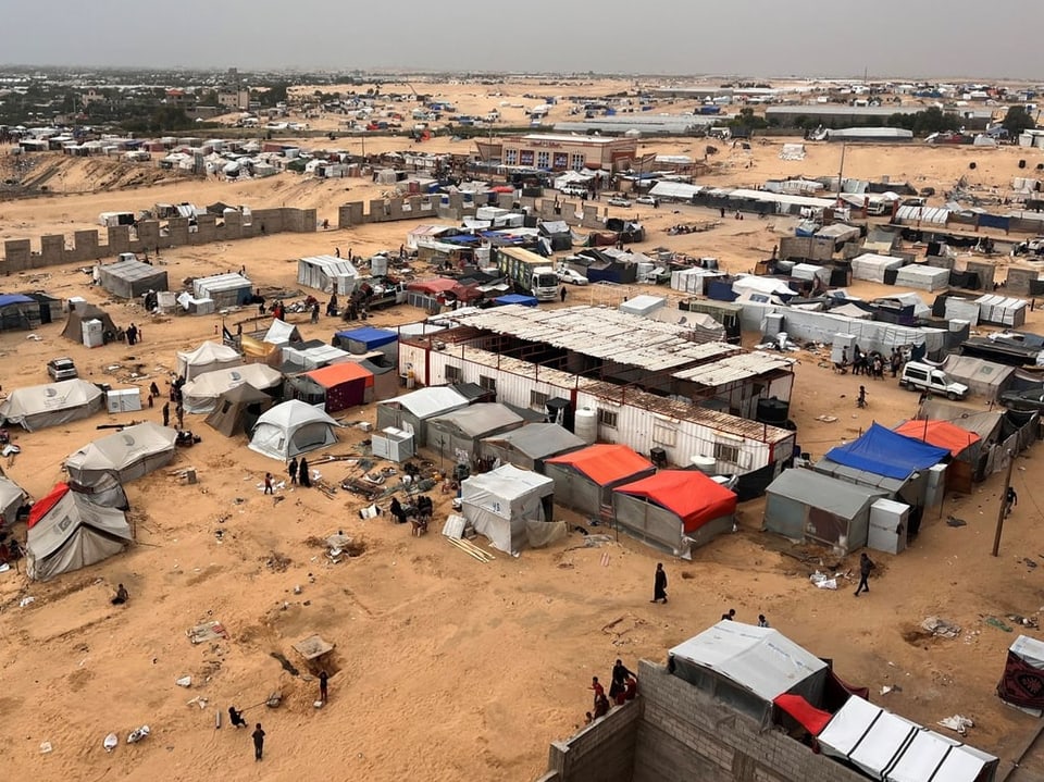 Luftaufnahme eines überfüllten Flüchtlingslagers in einer Wüstenregion.