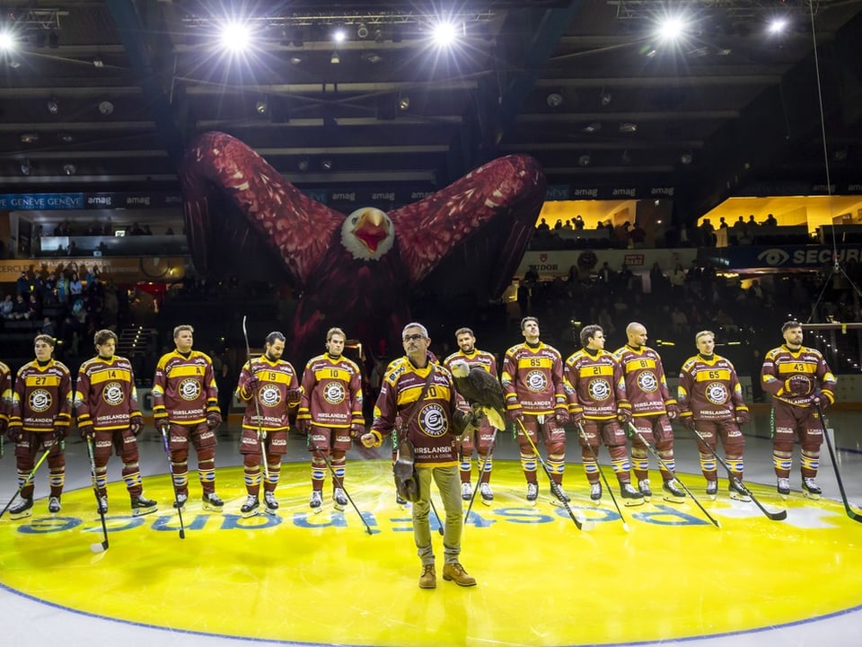 Eishockeyteam vor grosser Adlerkulisse in der Arena.