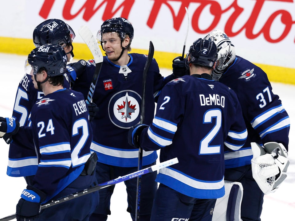 Eishockeyspieler der Winnipeg Jets feiern auf dem Eis.