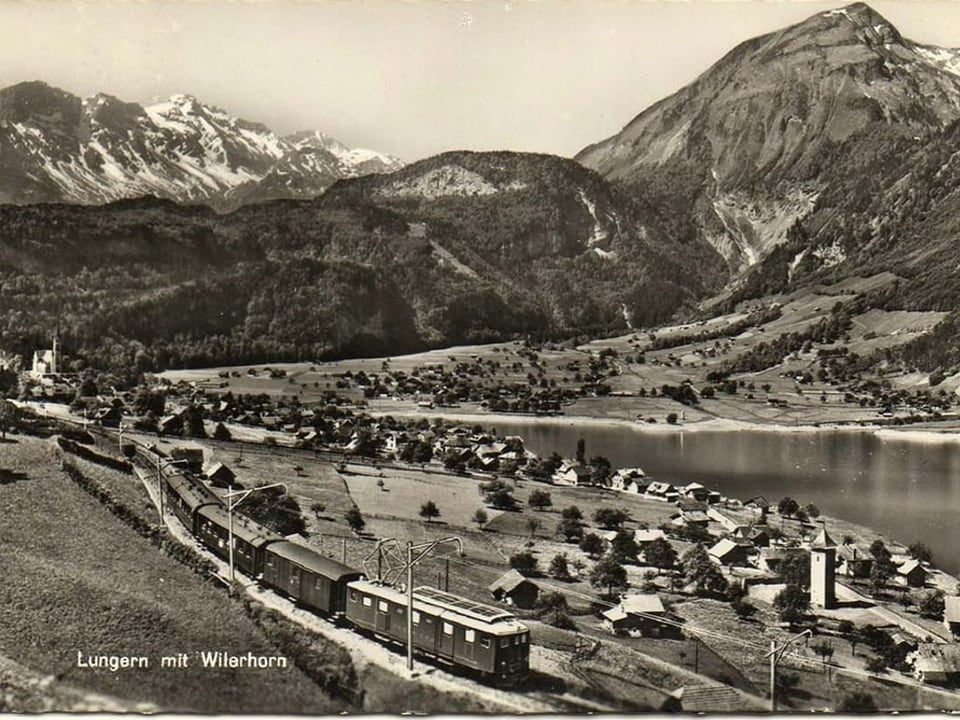 Im Vordergrund ein Zug der Brünigbahn, im Hintergrund Lungern. 