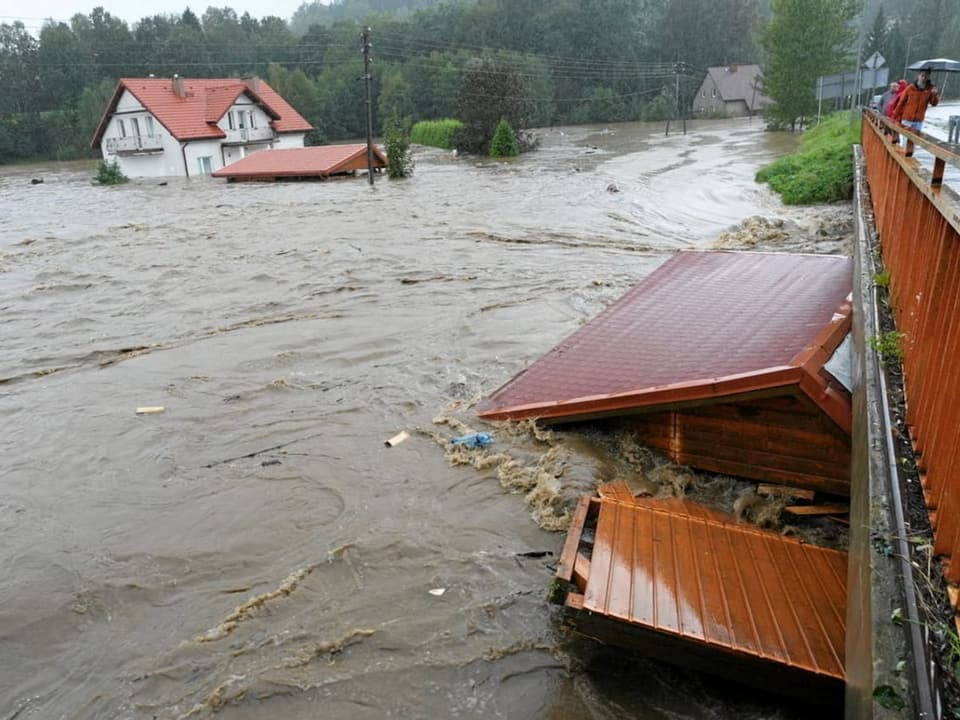 Stark überschwemmte Landschaft mit teilweise untergetauchten Gebäuden.