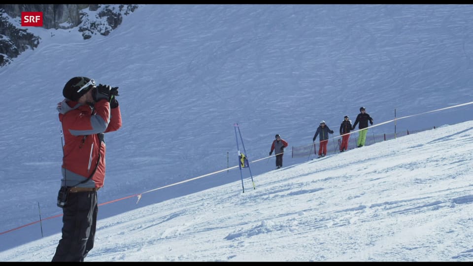 Trainer. mit Feldstecher im Schnee