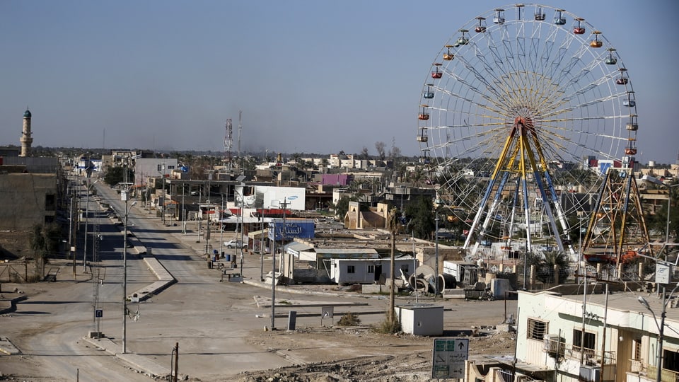 Blick auf eine verstaubte Stadt mit leeren Strassen, im Hintergrund ein Riesenrad.