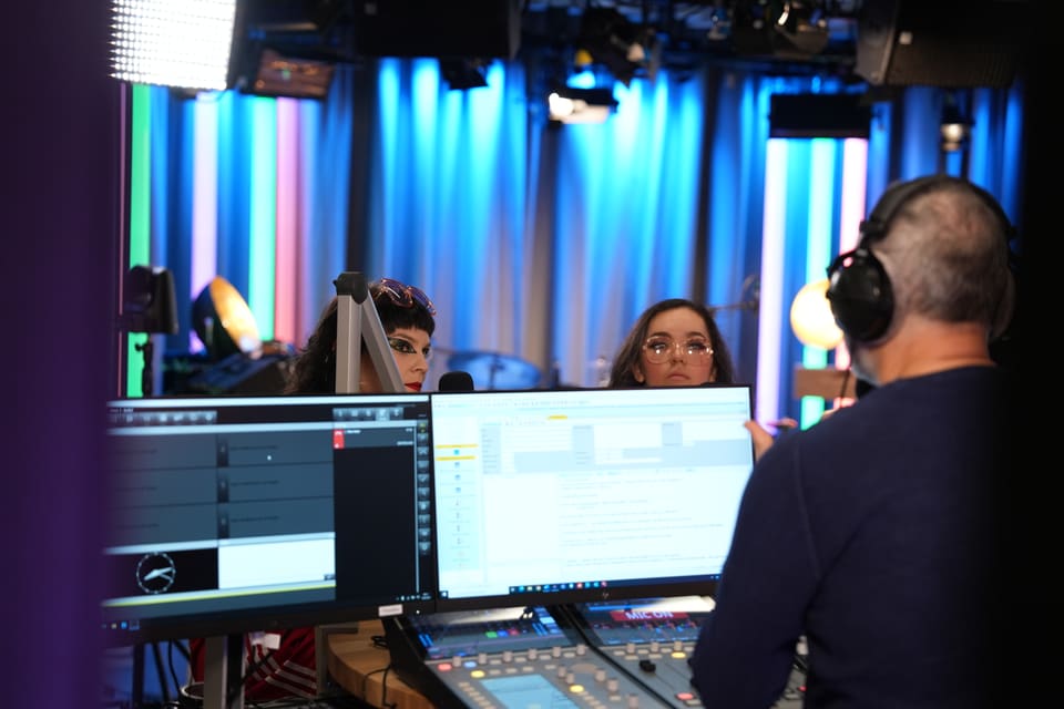 Personen in einem Studioumfeld mit Computern und Mischpult.