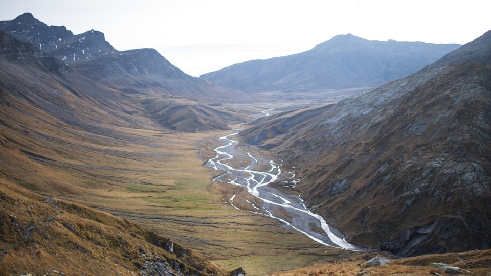 Aufblick auf der Schweizer Hochebene Greina mit Flusslauf in der Mitte und Berge zu beiden Seiten