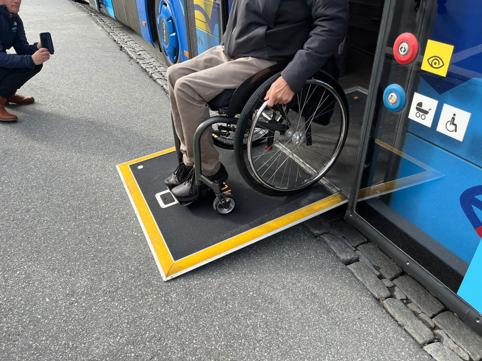 Rollstuhlfahrer benutzt Rampe, um in Bus einzusteigen.