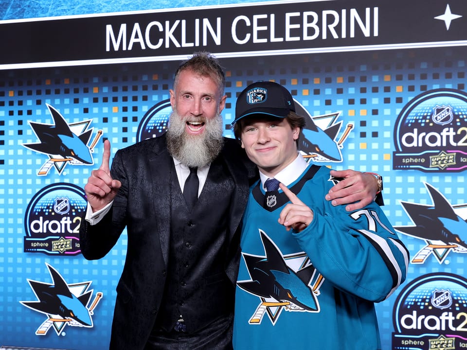 Zwei Männer feiern bei einem Eishockey-Draft-Event.
