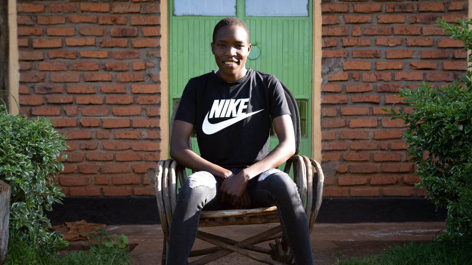 Grace Loibach sitzt vor ihrem Trainingszentrum in Iten. Sie trägt ein schwarzes T-Shirt mit Nike-Logo.