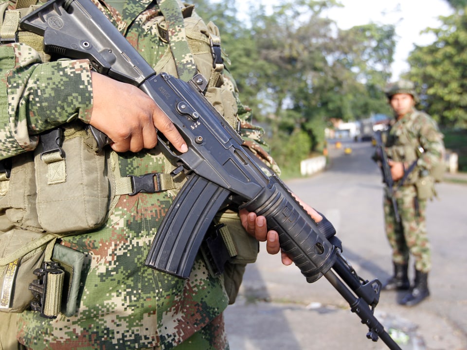 Ein Gewehr in der Nahaufnahme, das von einem kolumbianischen Soldaten gehalten wird. 