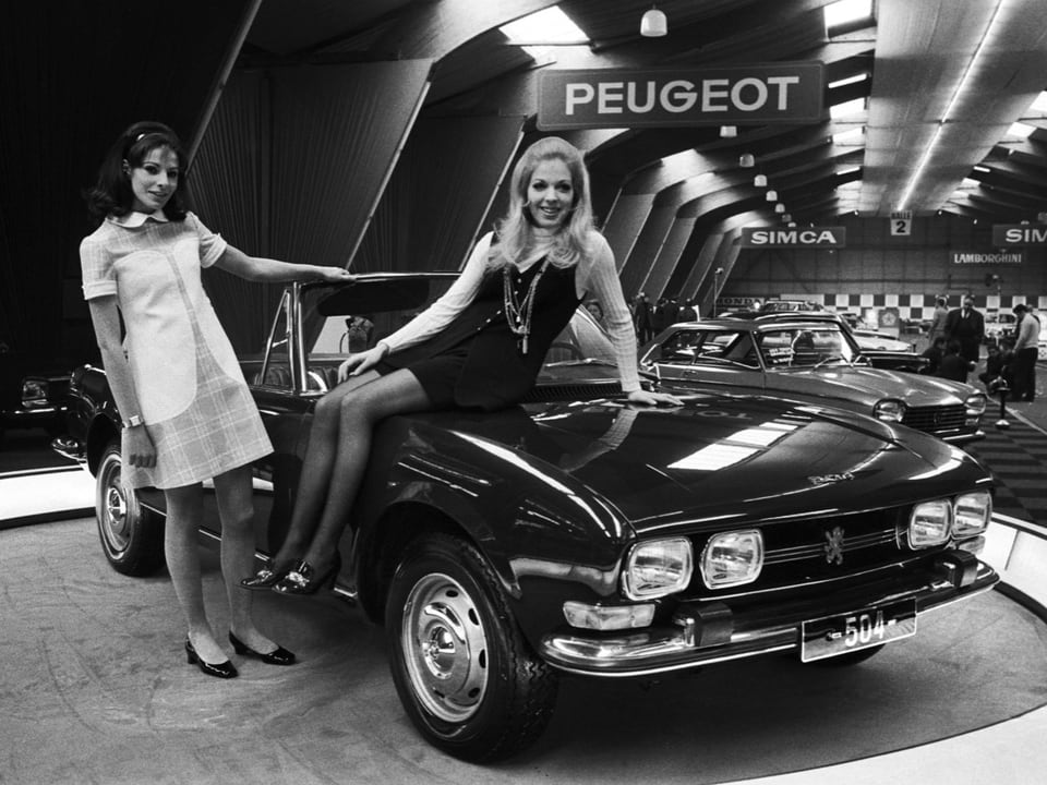 Zwei Frauen präsentieren ein Peugeot-Auto auf einer Autoshow.