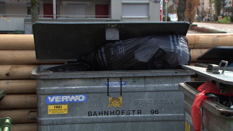 Container halb geöffnet, Sack schaut heraus