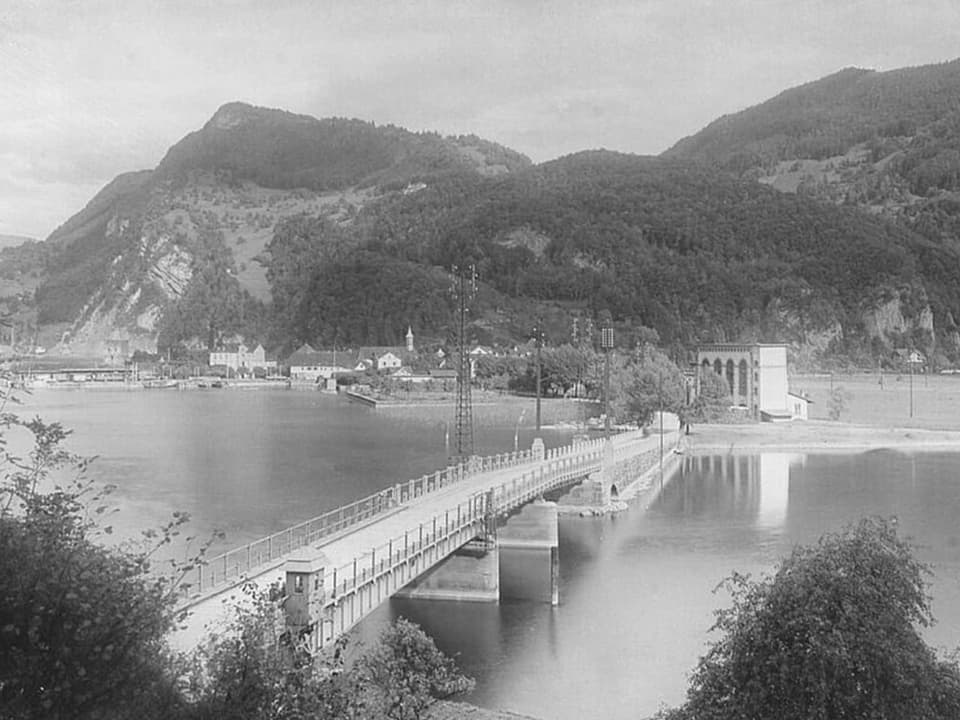 Historische Brücke über Fluss vor Bergen.