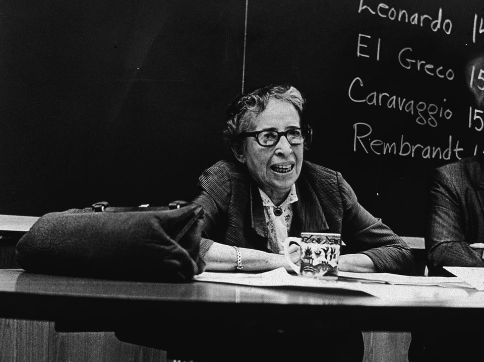 Hannah Arendt vor einer Schultafel.