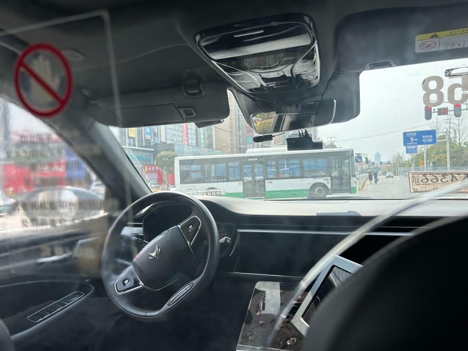 Blick aus einem Auto auf eine Kreuzung mit Bus.