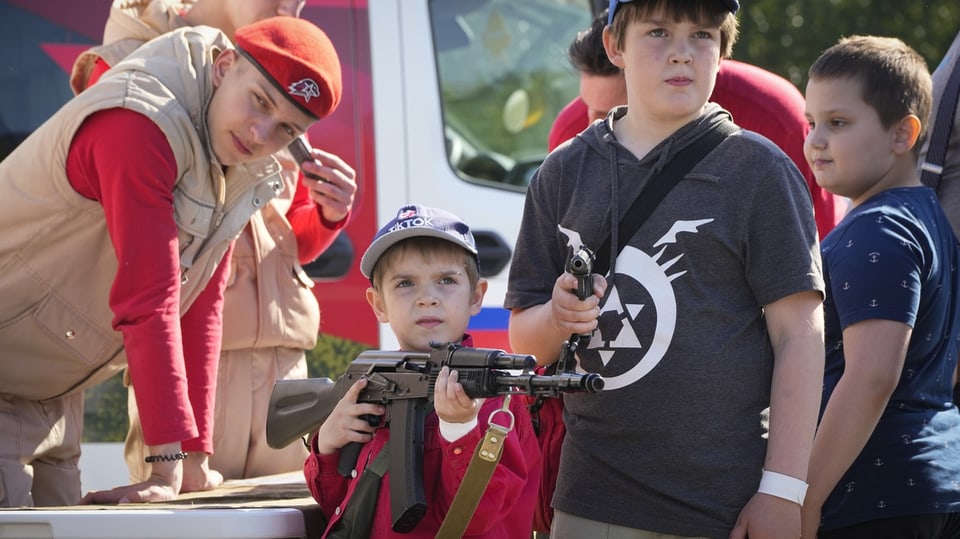 Kinder mit Gewehr.