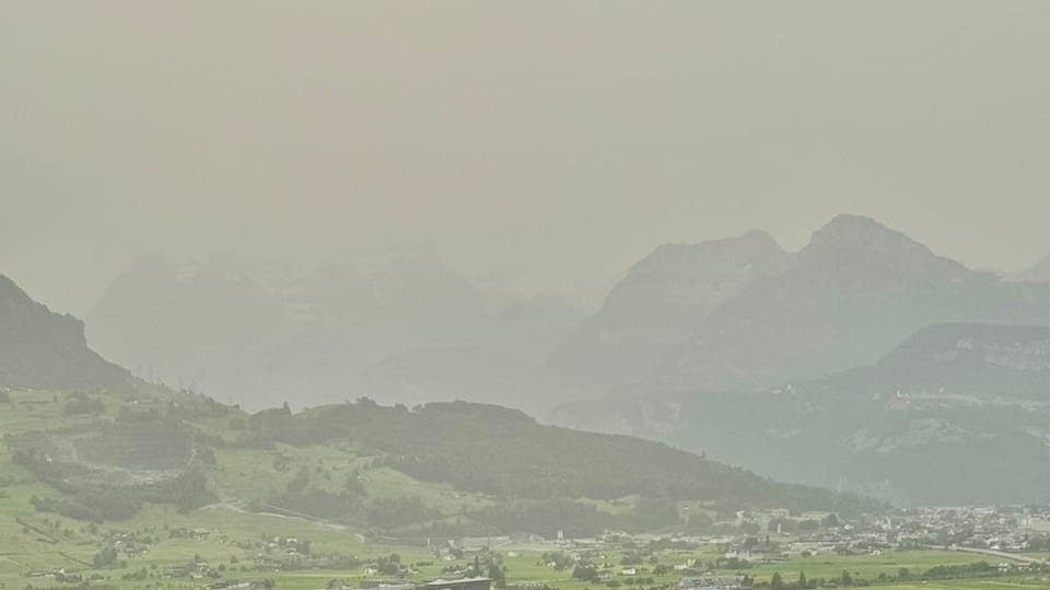 Landschaft mit Staub über Tälern und Bergen.